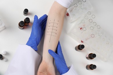 Doctor doing skin allergy test at light table, top view