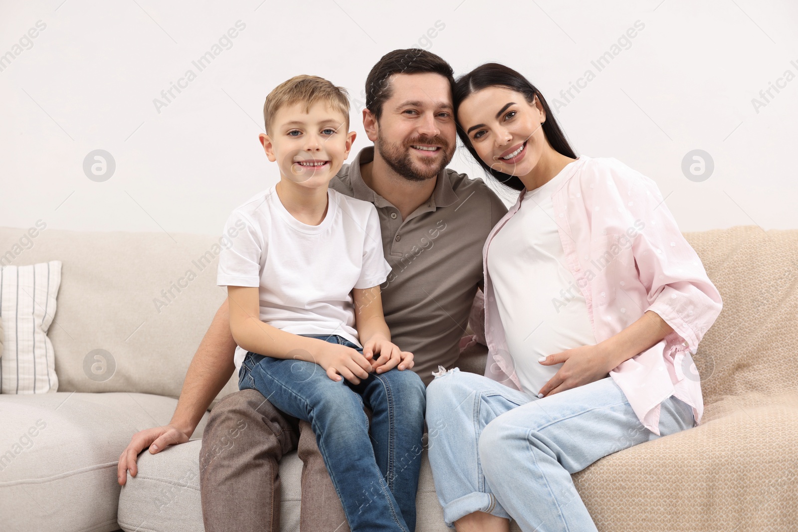 Photo of Portrait of happy pregnant woman with her son and husband at home