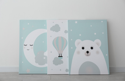 Photo of Different adorable pictures on floor near white wall. Children's room interior elements
