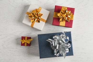 Flat lay composition with beautiful gift boxes on white wooden table