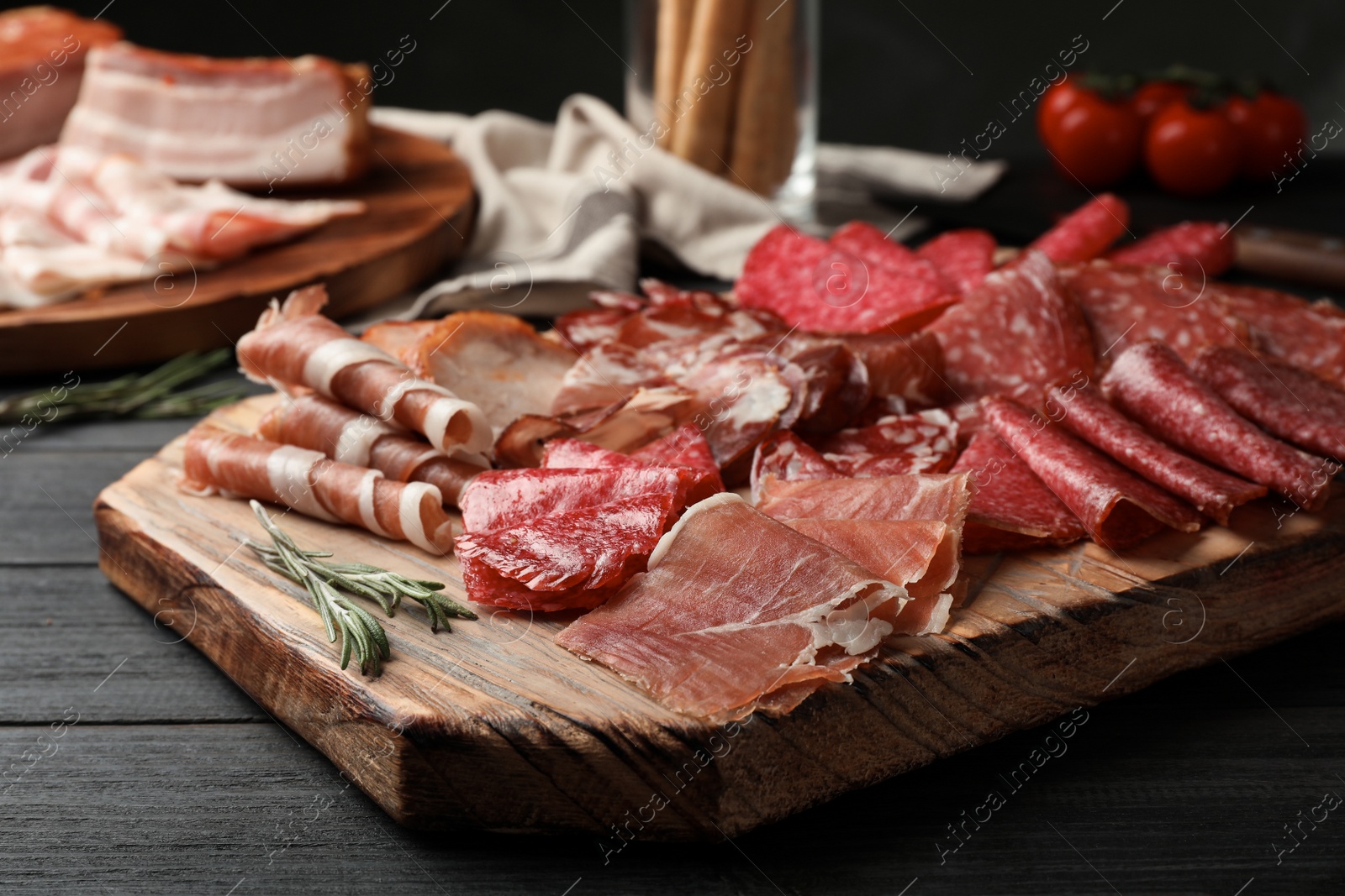 Photo of Cutting board with different sliced meat products served on table