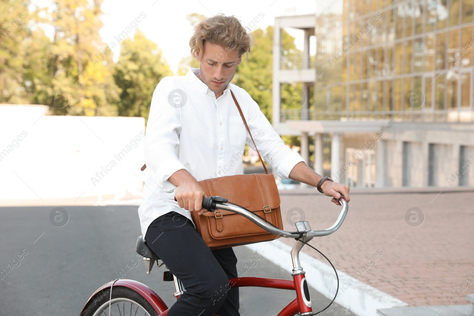 Photo of Attractive man riding bike on city street