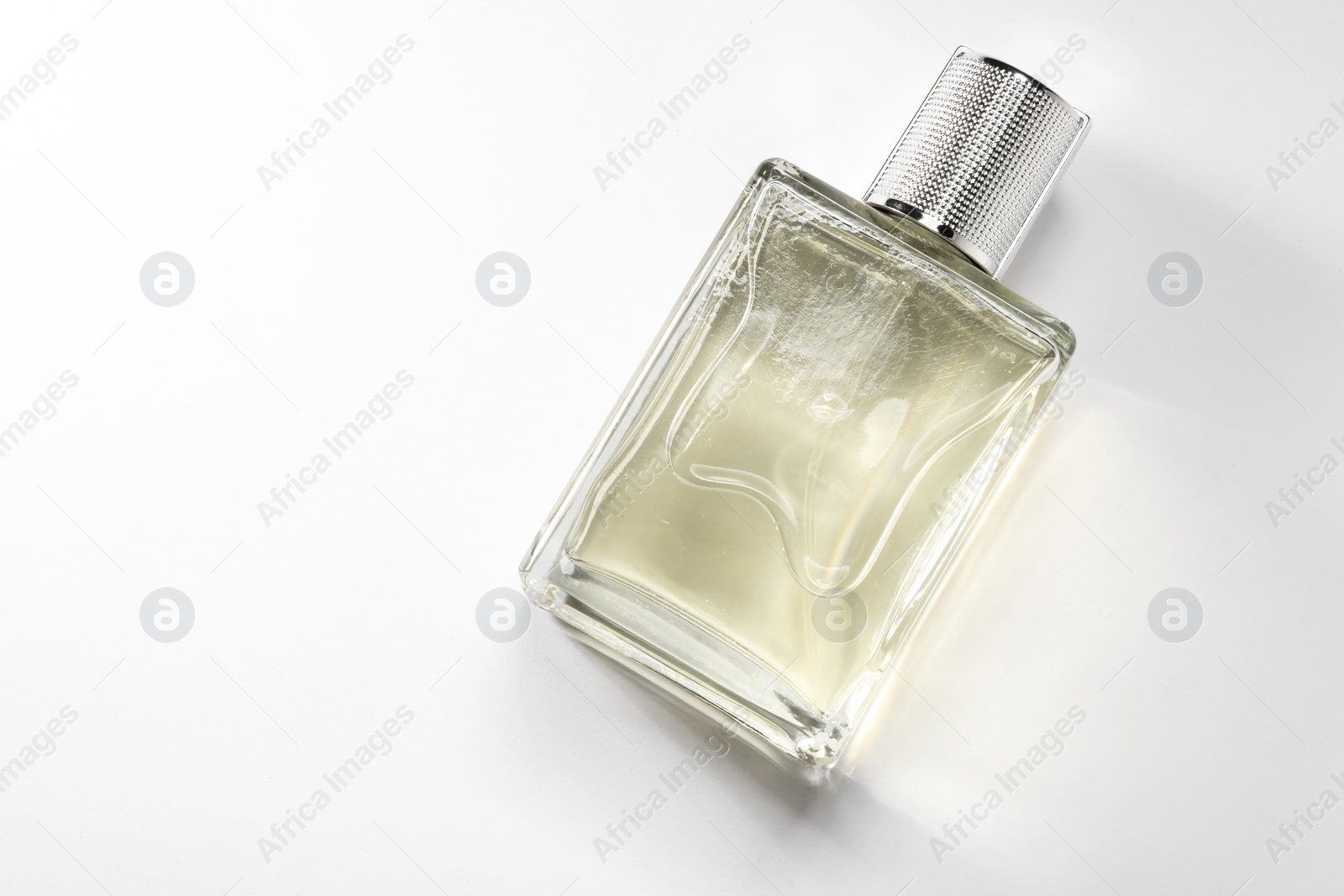 Photo of Luxury men`s perfume in bottle on white background, top view. Space for text