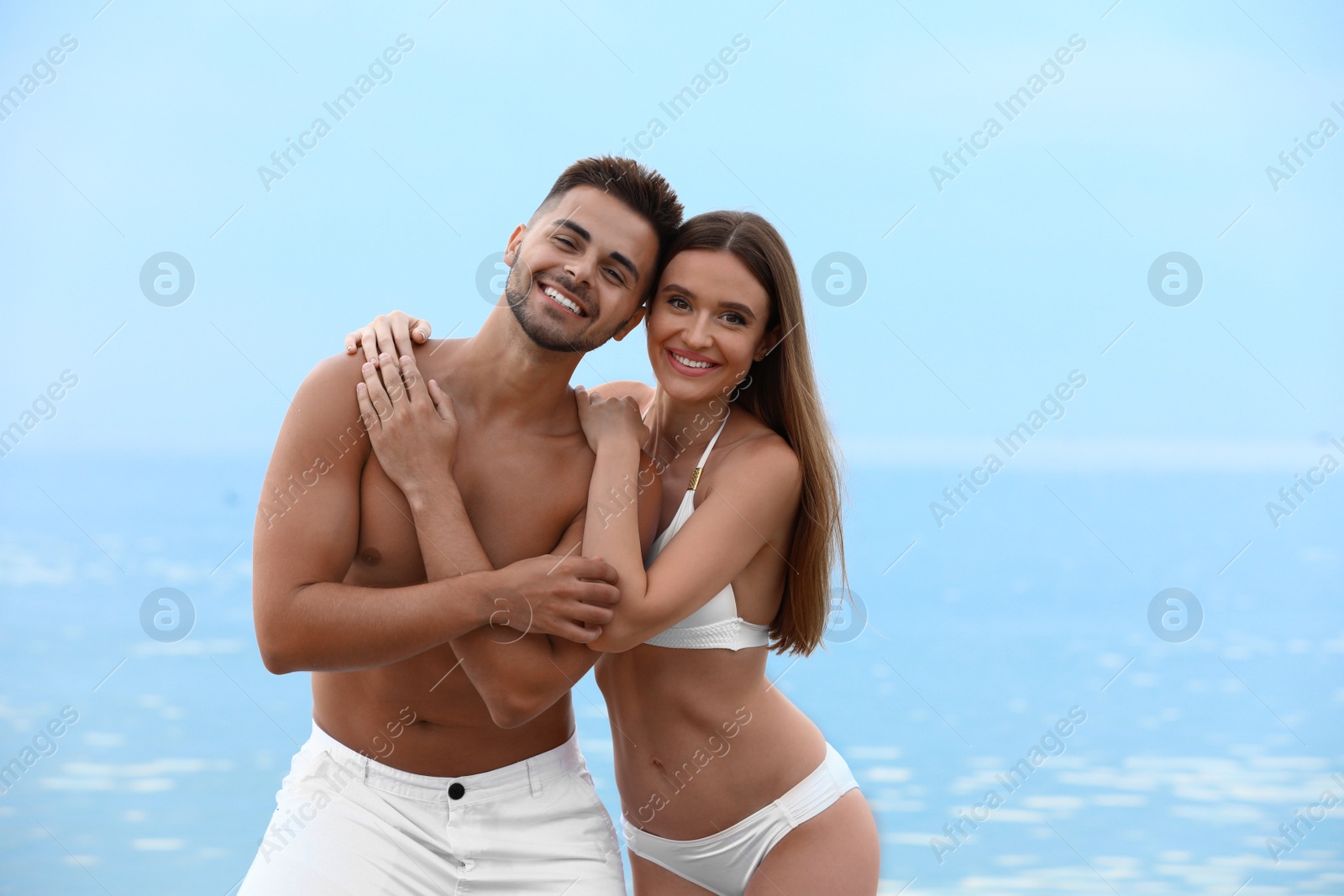 Photo of Young woman in bikini with her boyfriend on beach, space for text. Lovely couple