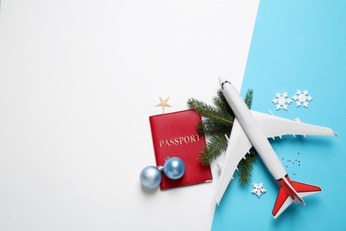 Flat lay composition with Christmas decorations and passport on color background, space for text. Winter vacation