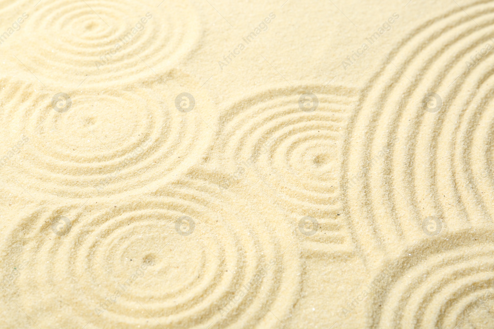 Photo of Zen rock garden. Circle patterns on beige sand, closeup