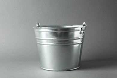 Photo of One shiny metal bucket on light grey background