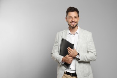 Happy teacher with stationery against beige background