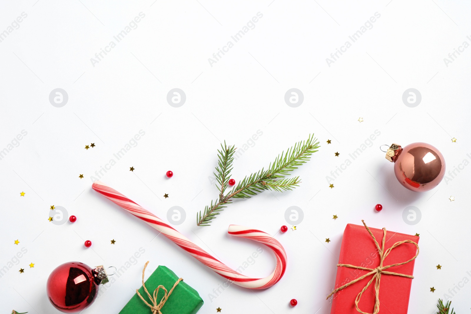 Photo of Flat lay composition with Christmas gifts and festive decor on white background. Space for text