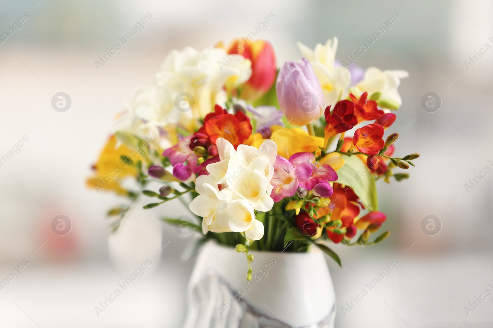 Photo of Beautiful bouquet of freesia flowers on blurred background