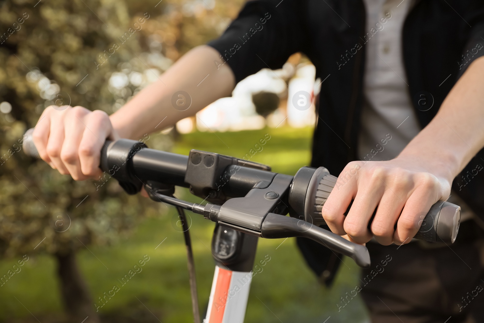 Photo of Man riding modern electric scooter in park, closeup