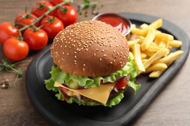 Photo of Delicious burger with beef patty, tomato sauce and french fries on wooden table, closeup