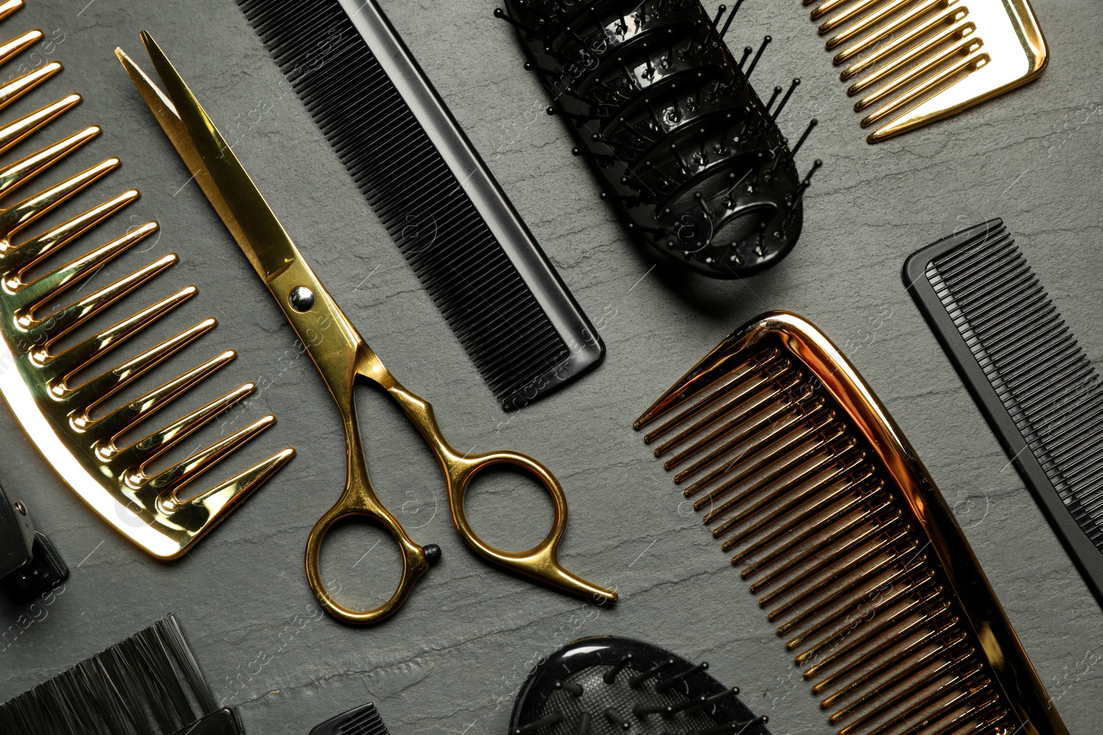 Photo of Hairdressing tools on grey textured background, flat lay