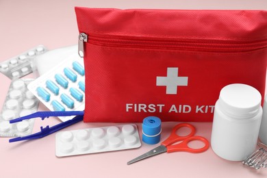 Photo of First aid kit on pink background, closeup