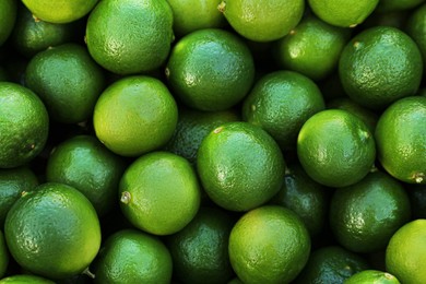 Fresh ripe green limes as background, top view