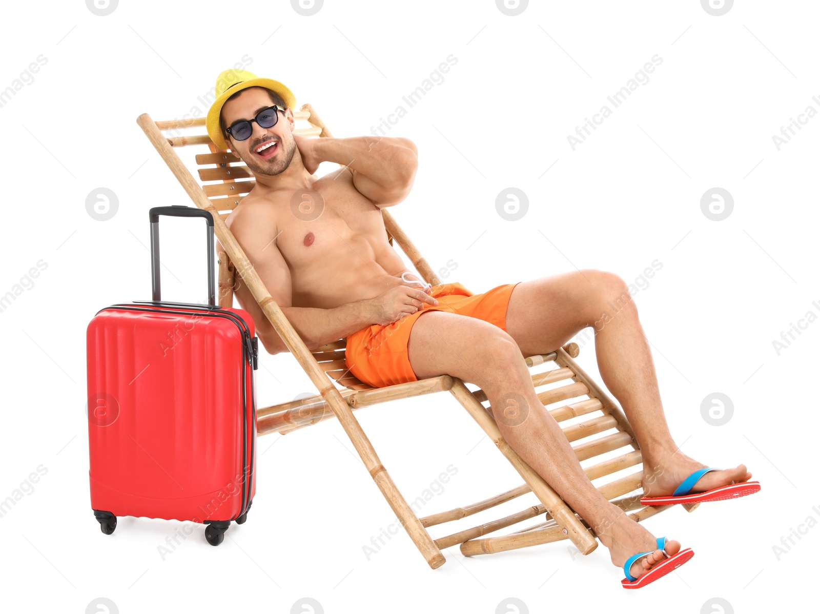 Photo of Young man with suitcase on sun lounger against white background. Beach accessories