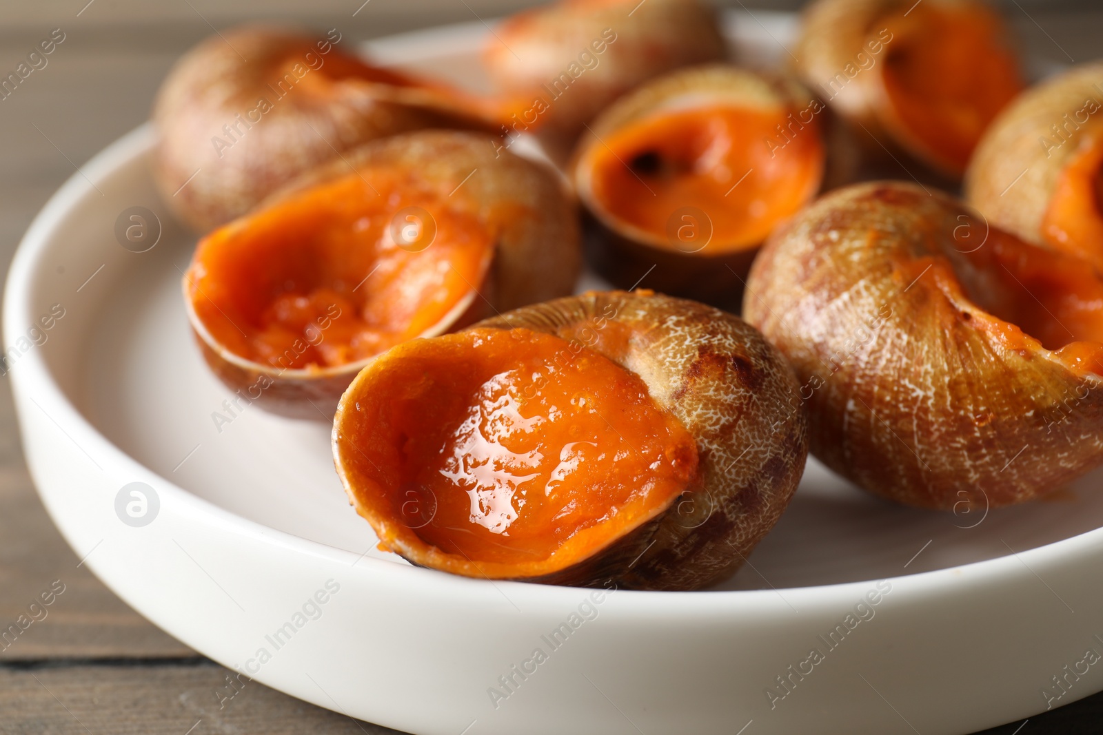 Photo of Delicious cooked snails on table, closeup view