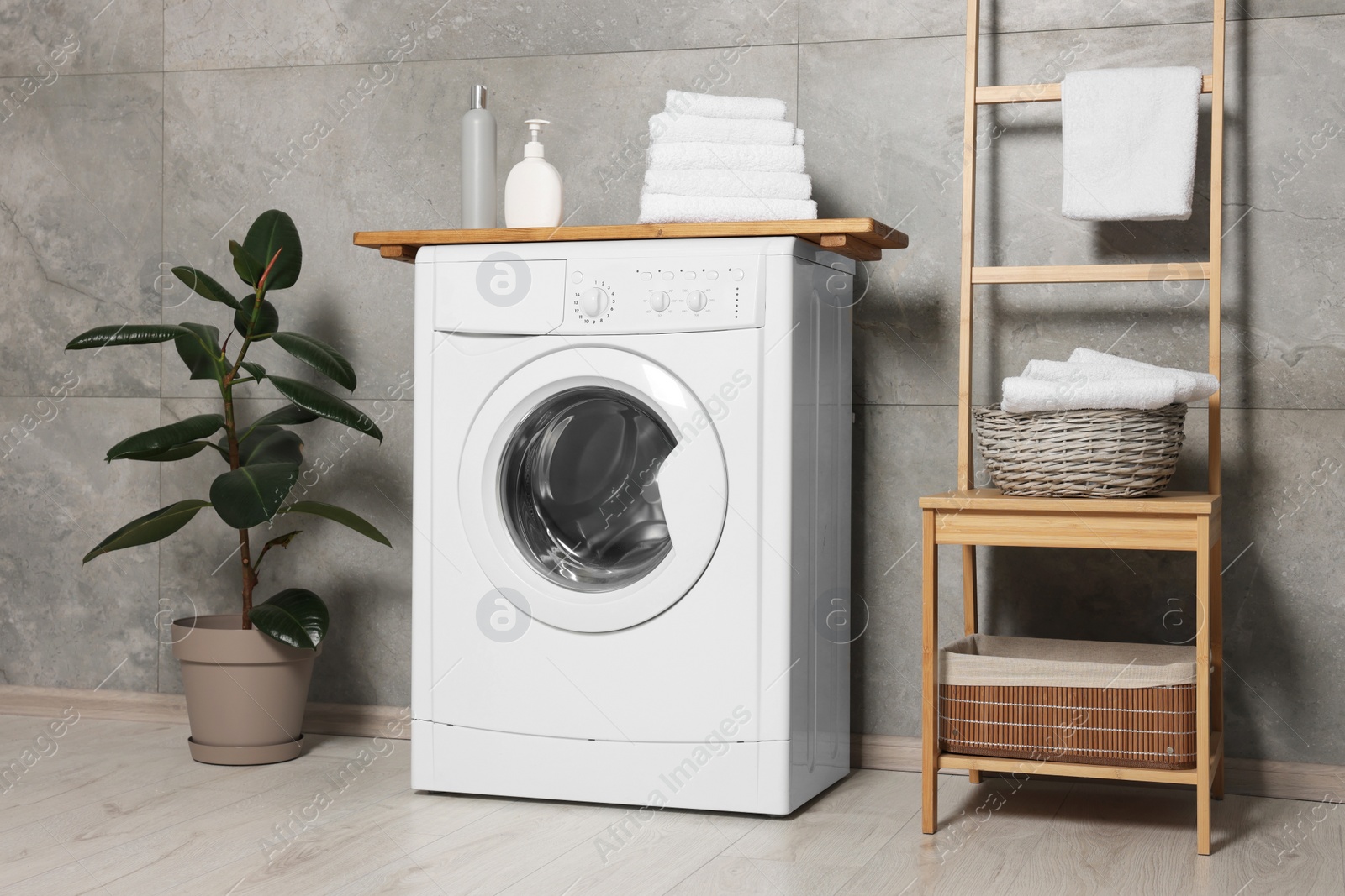 Photo of Stylish laundry room with modern washing machine. Interior design