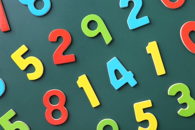 Photo of Colorful numbers on green background, flat lay