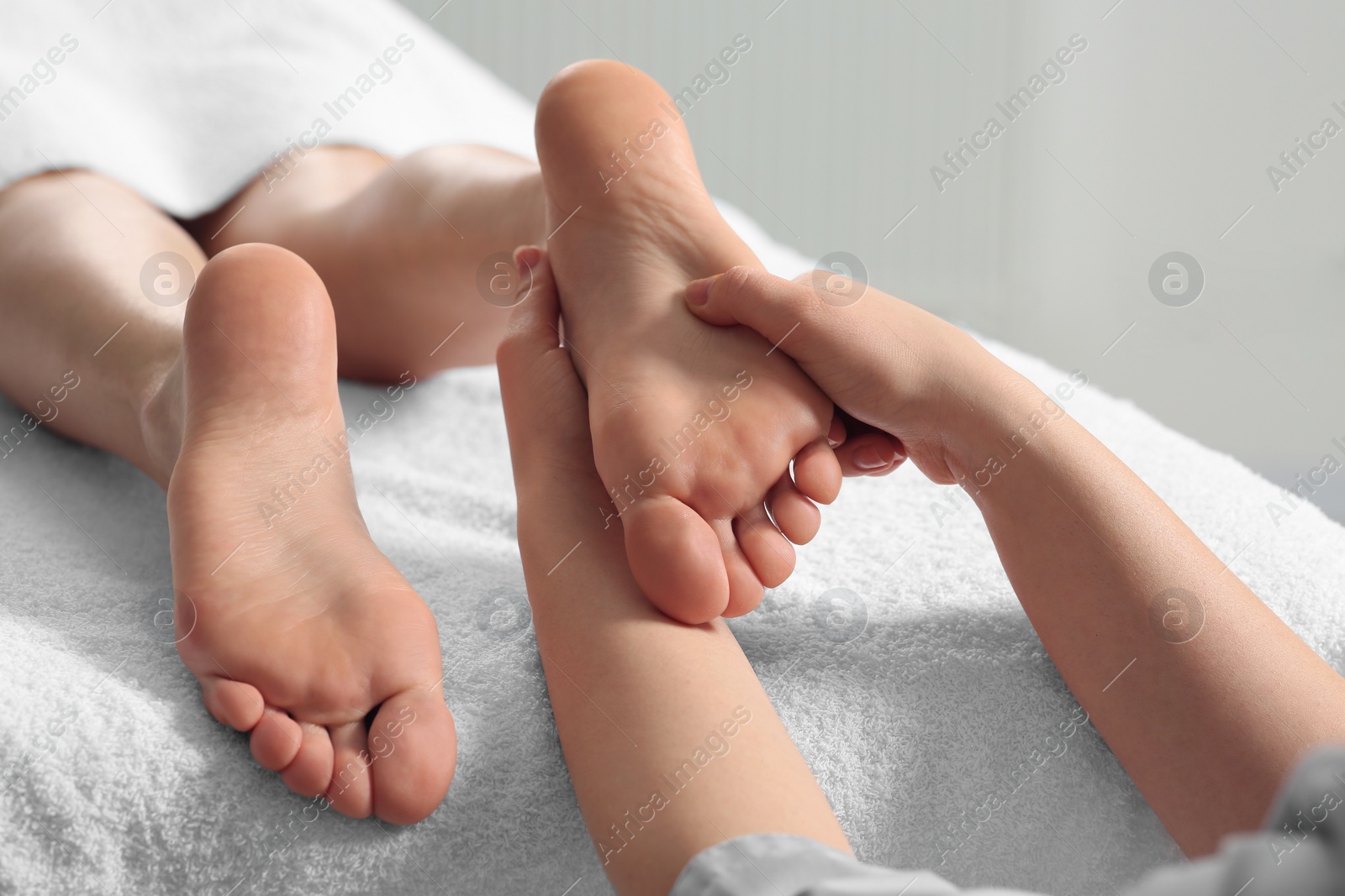 Photo of Woman receiving foot massage in spa salon, closeup