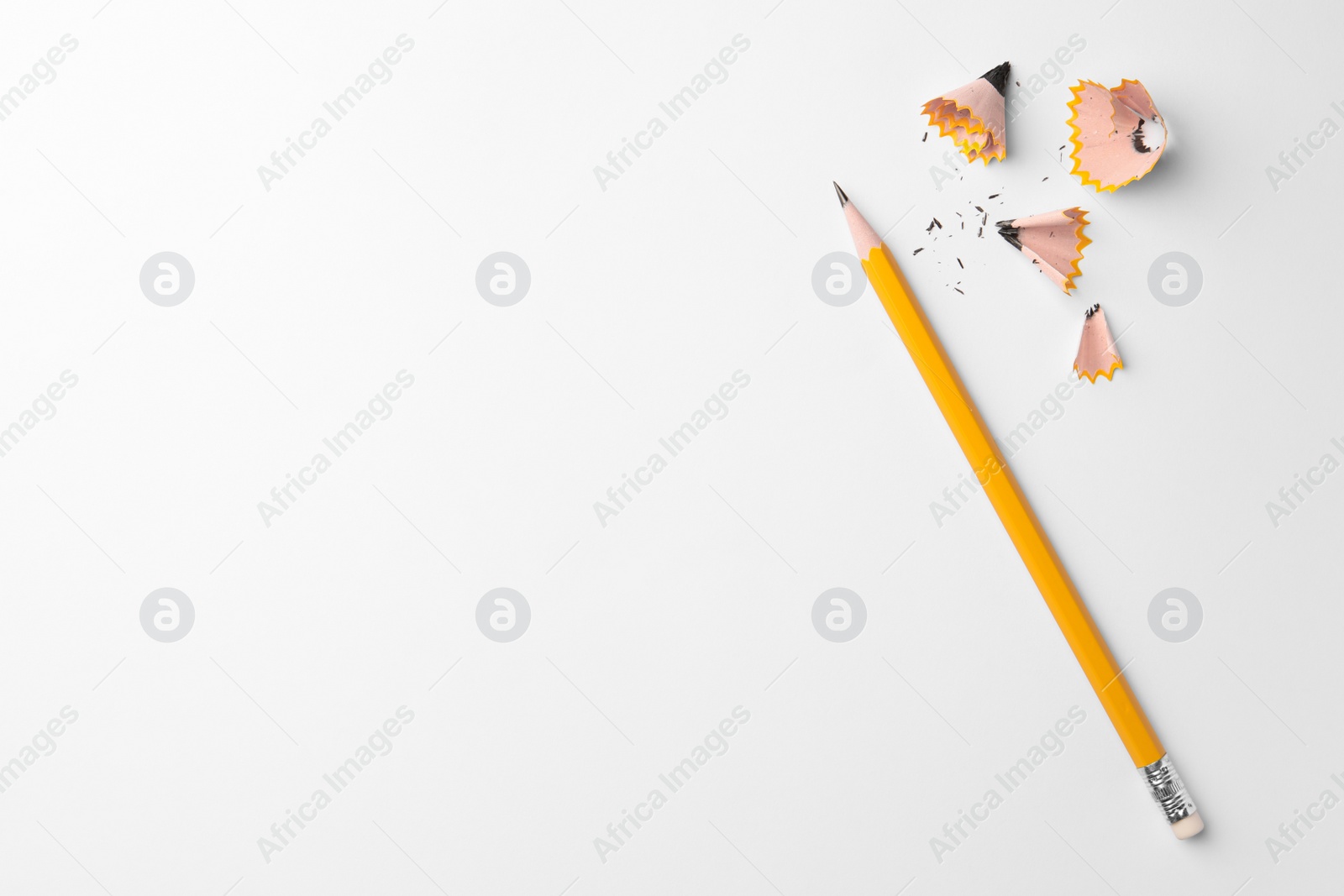 Photo of Graphite pencil and shavings on white background, flat lay. Space for text