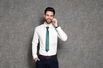 Photo of Portrait of businessman talking on phone against grey background