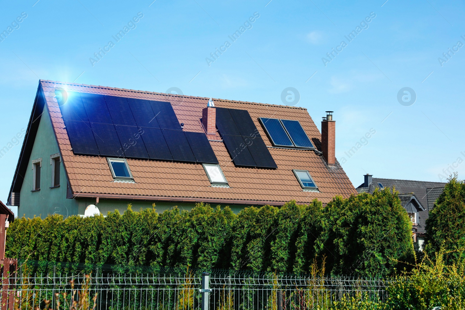 Photo of House with installed solar panels on roof. Alternative energy