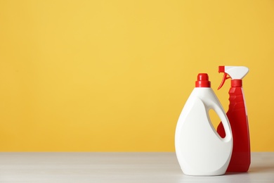 Photo of Bottles of cleaning products on light table. Space for text