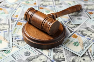 Wooden Judge's gavel on dollar banknotes, closeup