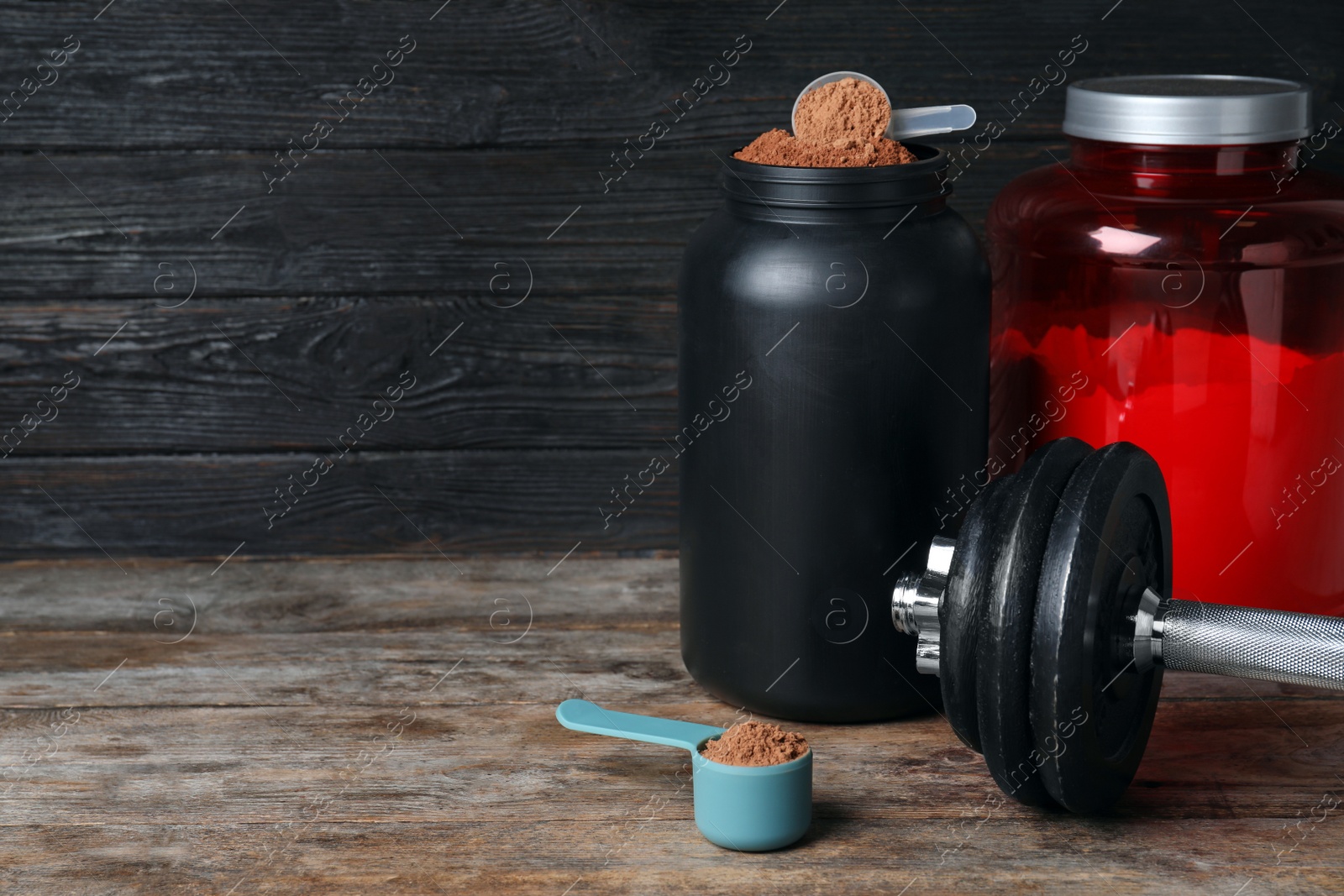 Photo of Composition with protein powder and dumbbell on table. Space for text