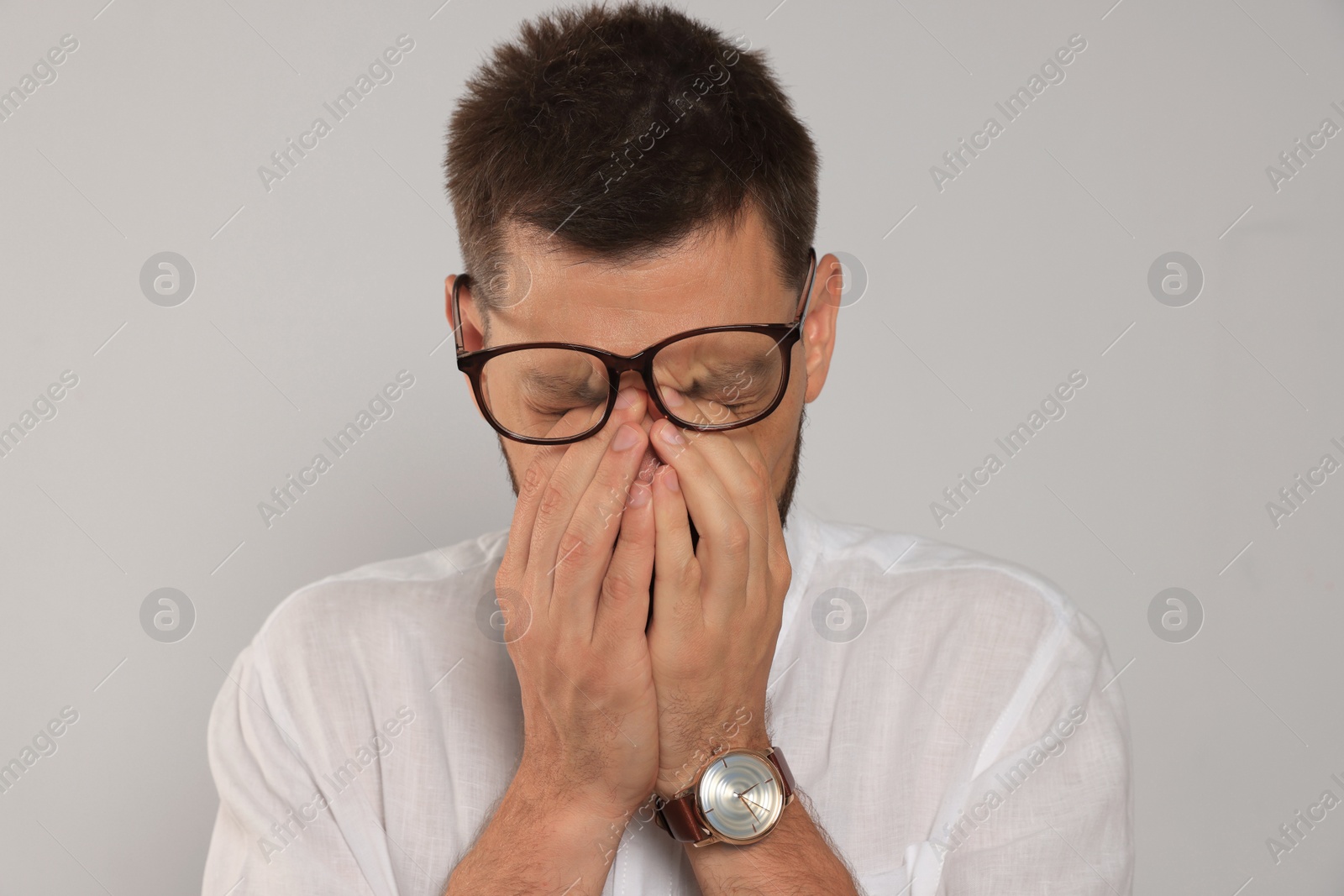 Photo of Man suffering from eyestrain on light background