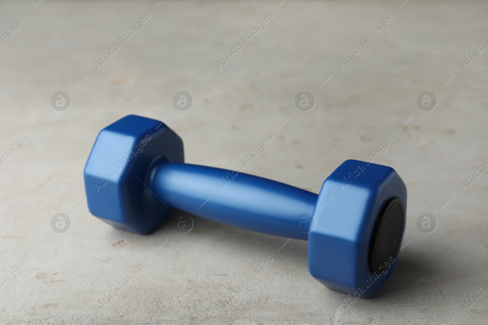 Photo of Blue vinyl dumbbell on light grey table