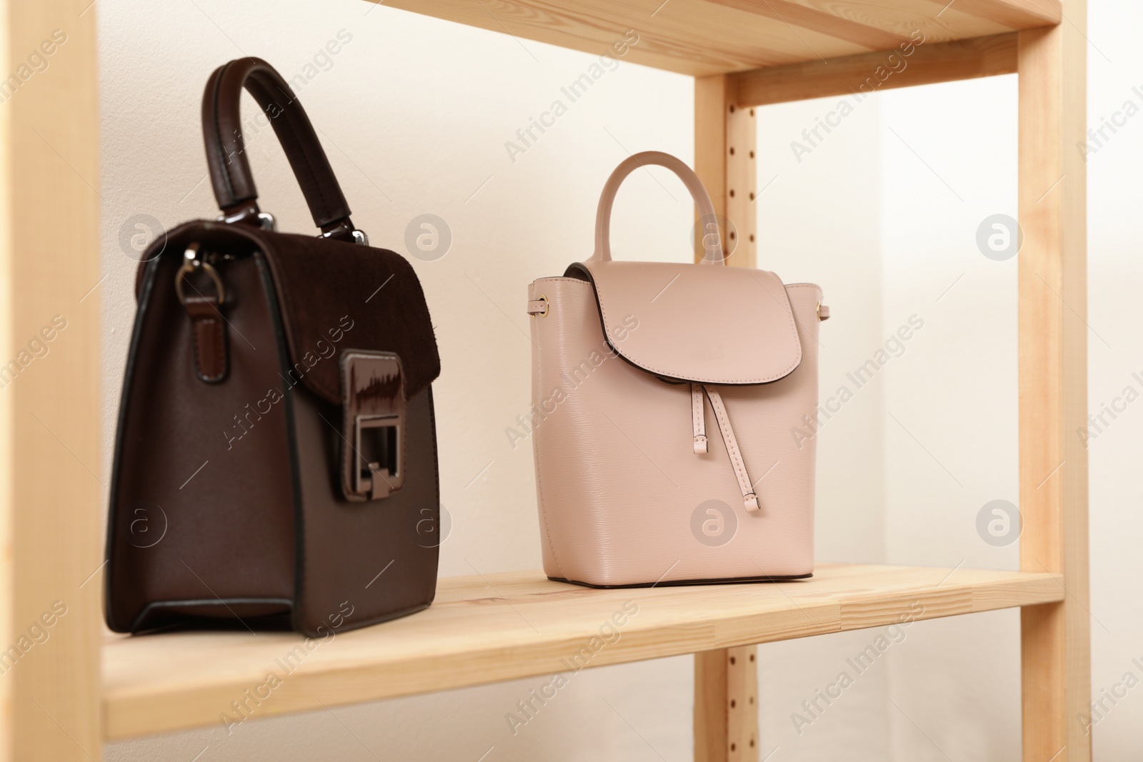 Photo of Stylish woman's bags on shelf in boutique