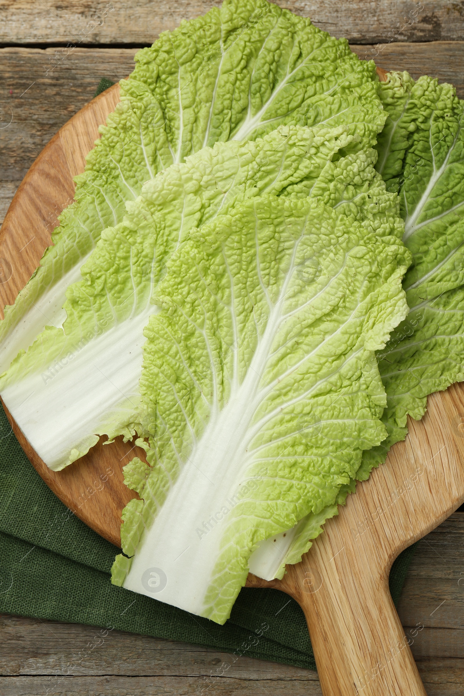 Photo of Fresh leaves of Chinese cabbage on wooden table, top view