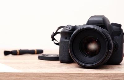Professional camera on table against white background, space for text. Photographer's equipment