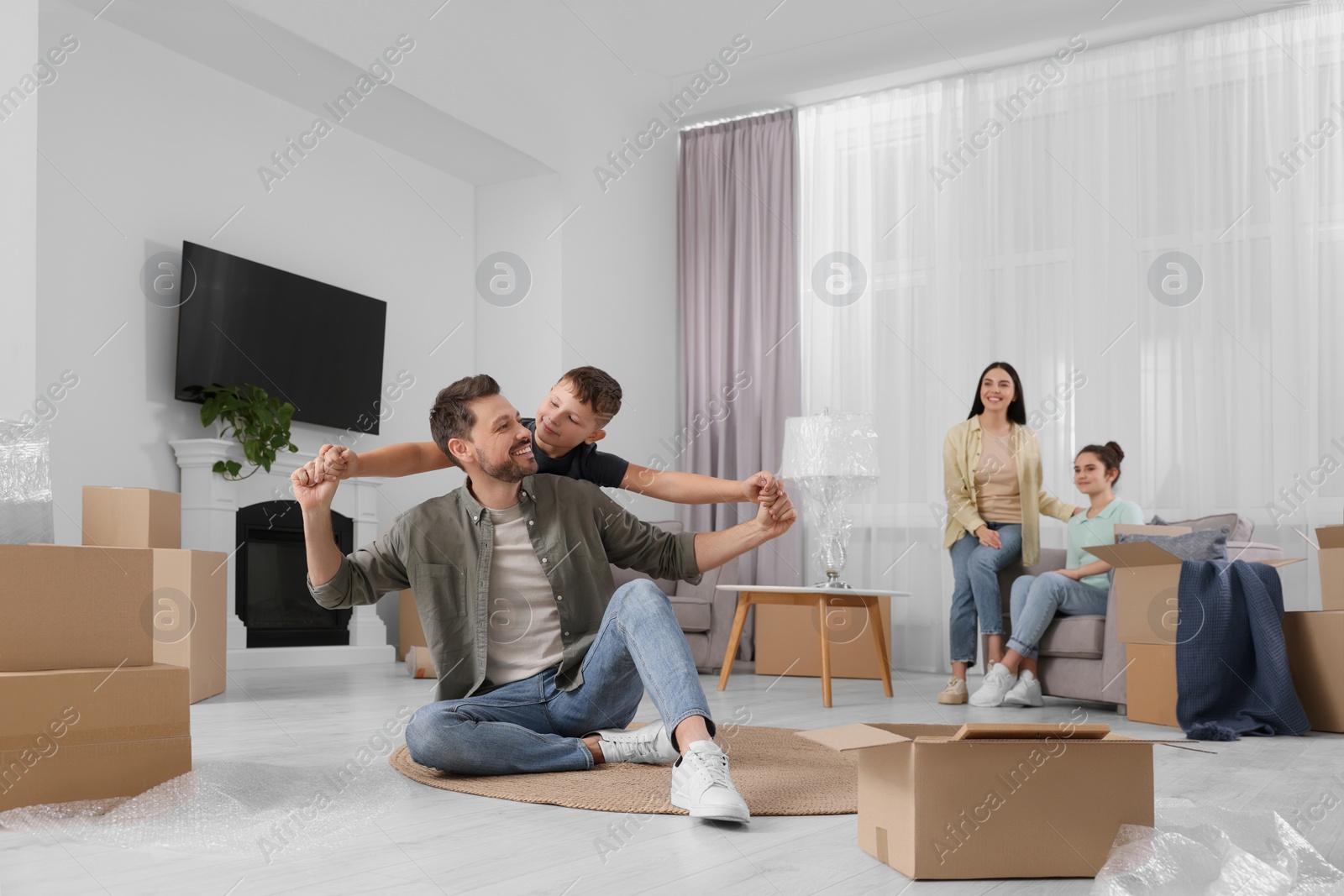 Photo of Happy family spending time in new apartment. Moving day