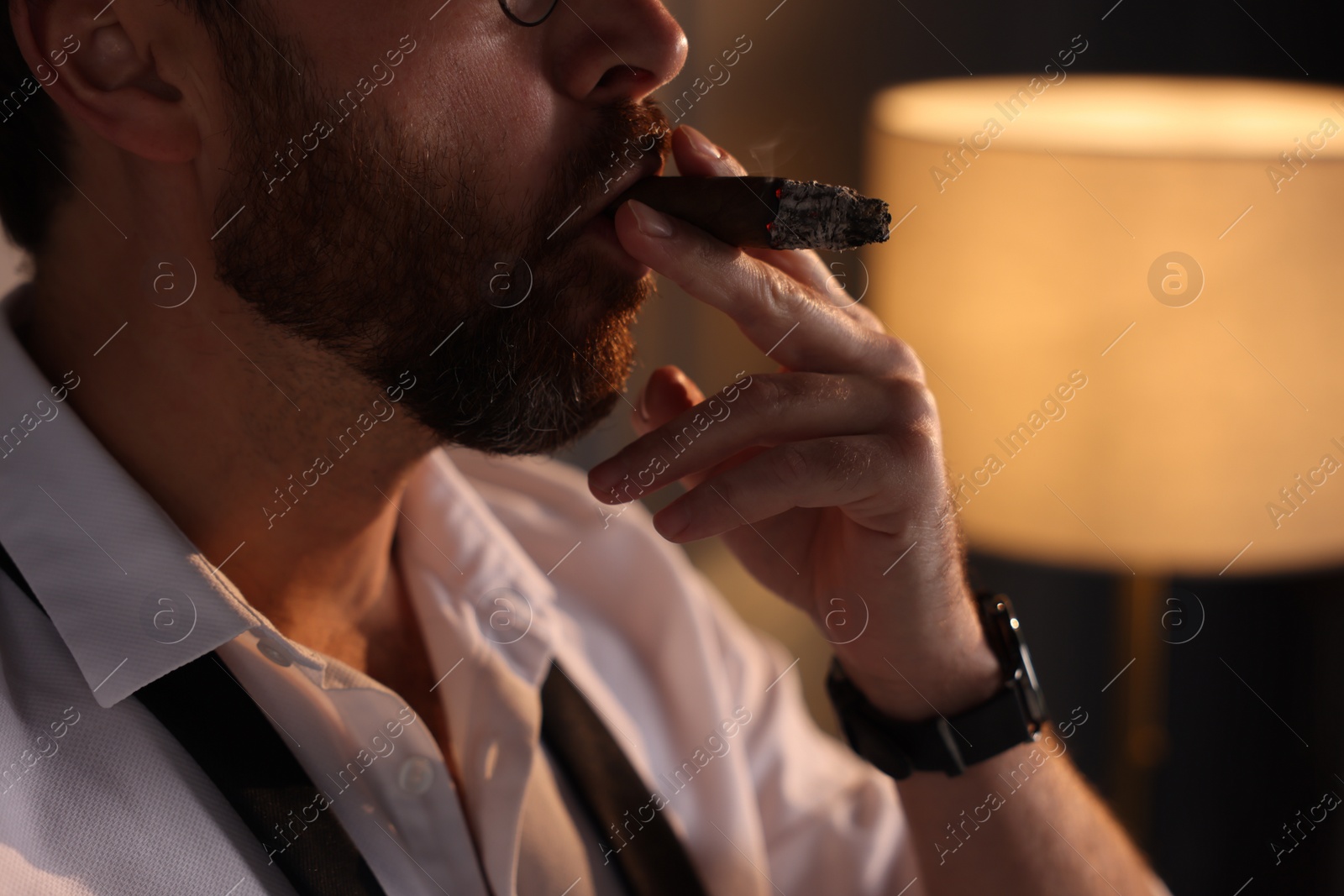 Photo of Man smoking cigar at home, closeup view