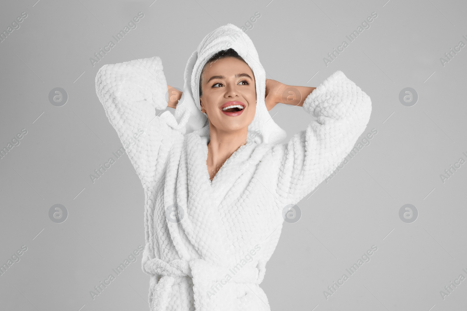 Photo of Beautiful young woman in bathrobe on light grey background