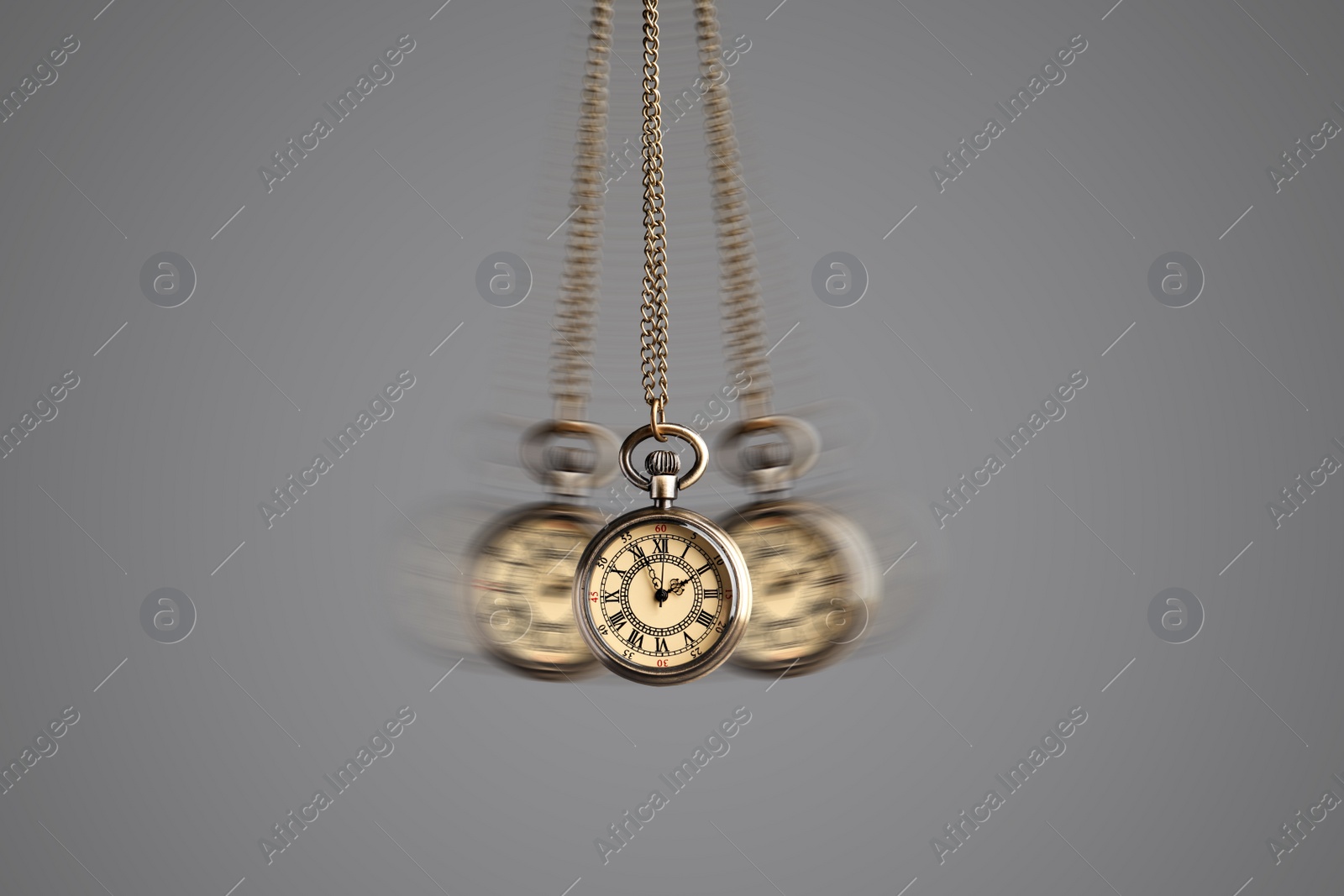 Image of Hypnosis session. Vintage pocket watch with chain swinging on grey background, motion effect