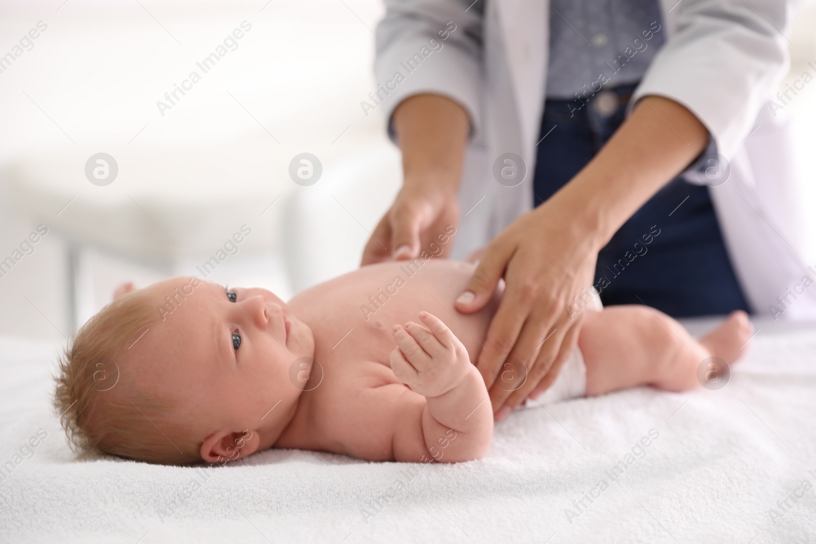 Photo of Doctor examining cute baby indoors, closeup. Health care