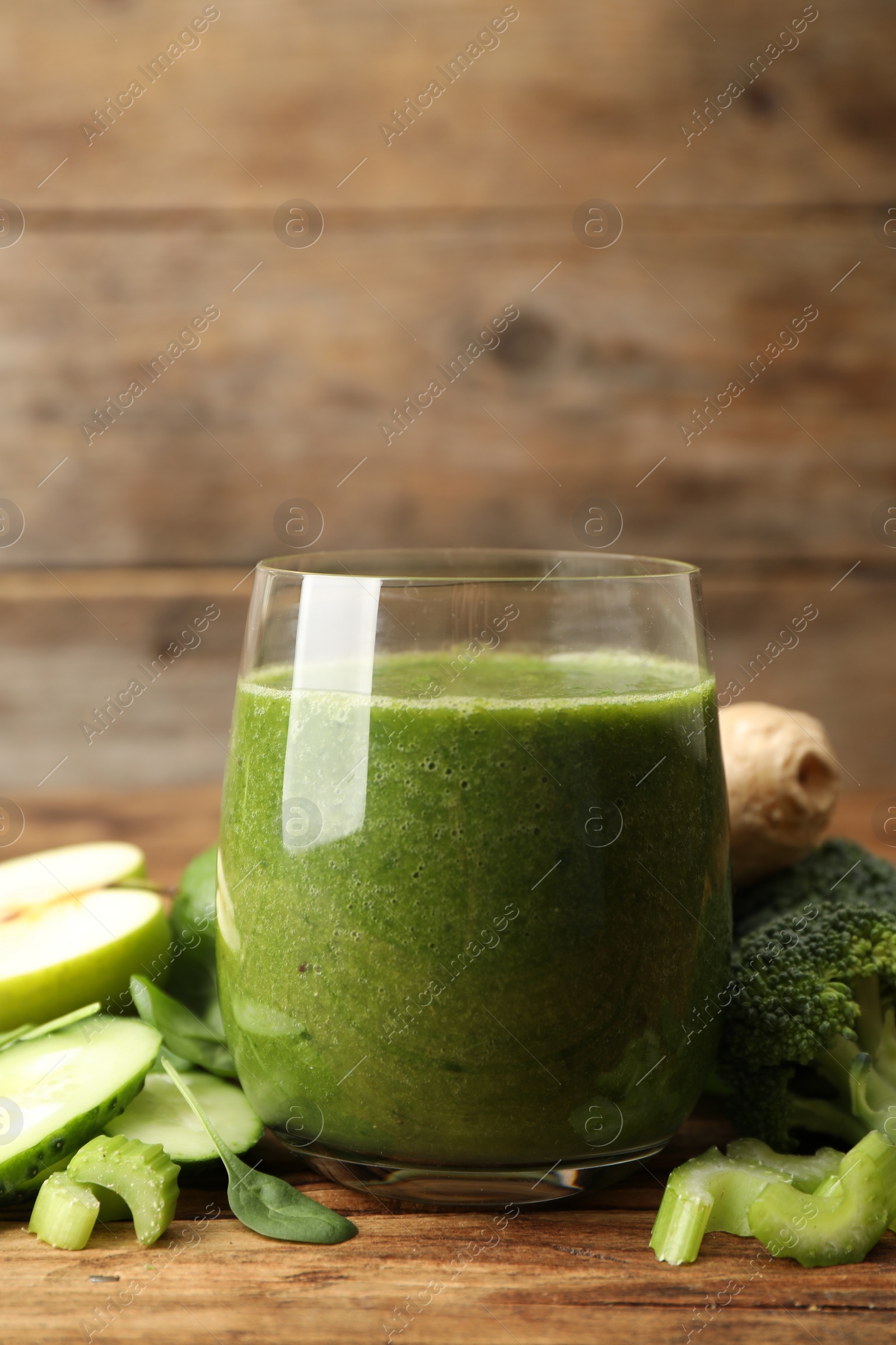 Photo of Green juice and fresh ingredients on wooden table