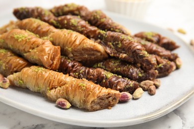 Delicious baklava with pistachio nuts on white marble table, closeup