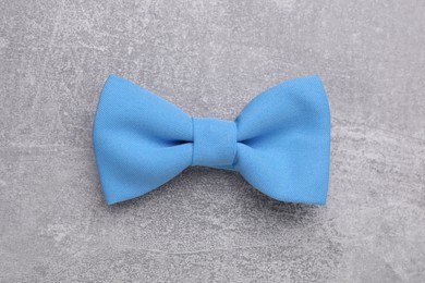 Stylish color bow tie on light grey table, top view