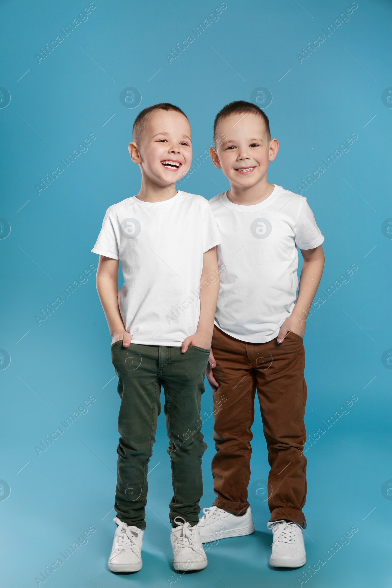 Photo of Full length portrait of cute twin brothers on color background