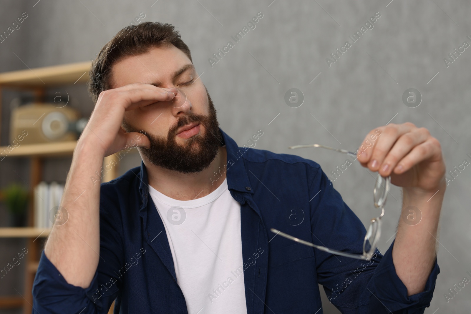 Photo of Overwhelmed man with glasses suffering at home