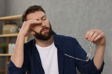 Photo of Overwhelmed man with glasses suffering at home