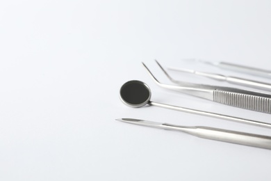 Photo of Set of different dentist tools on white background, closeup. Space for text