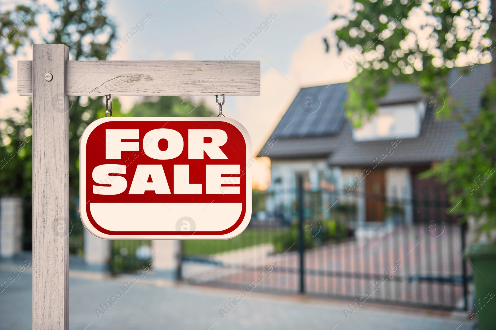 Image of Sale sign near beautiful house outdoors. Red signboard with words