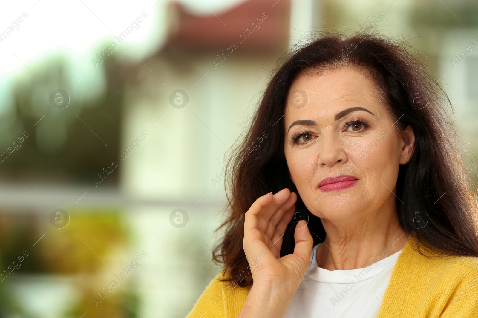 Photo of Portrait of beautiful older woman against blurred background with space for text