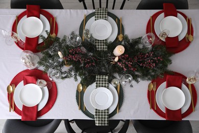 Photo of Christmas table setting with festive decor and dishware, top view